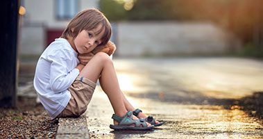 Boy Sitting On Curb